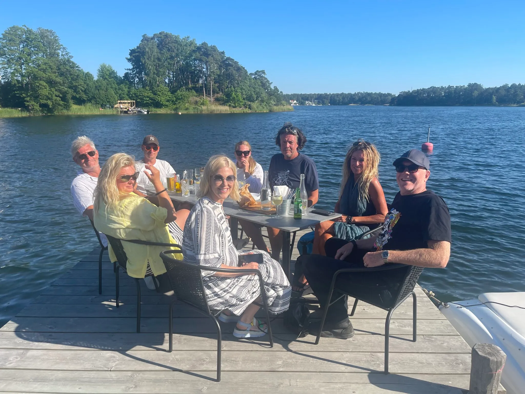 Gäster runt bordet på bryggan en sommardag